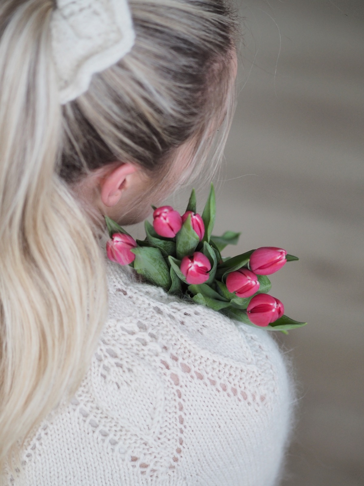 jente fotografert bakfra med dahliagenser og tulipaner